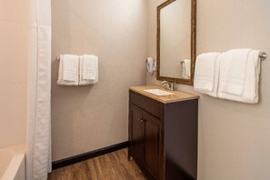 A bathroom with a shower, a sink, a mirror, and two towels. - 1 King Bed | Non-Smoking, Micfridge (Ridgecrest CA)