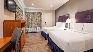 A hotel room with two beds, a desk, a chair, a TV, and a patterned curtain. - 2 Queen Beds | Non-Smoking, Micfridge (Ridgecrest CA)
