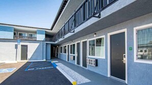 A building with a series of doors and windows, a ramp leading to an entrance, and a parking area marked 'NO PARKING'. - Spacious 2-Bed Queen|Fridge|Pool (Ridgecrest CA)