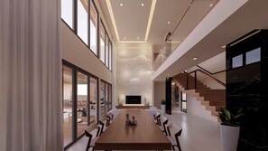 A spacious interior with a long dining table, a staircase, and a modern design.