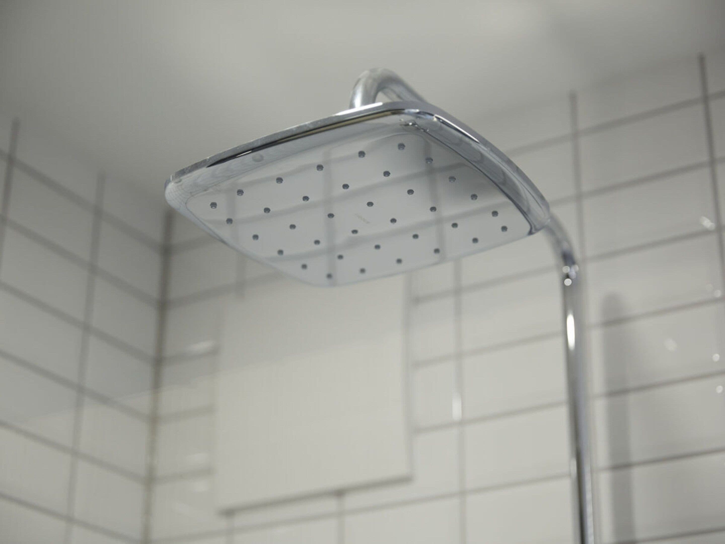 Un pommeau de douche au design carré et doté de plusieurs orifices.