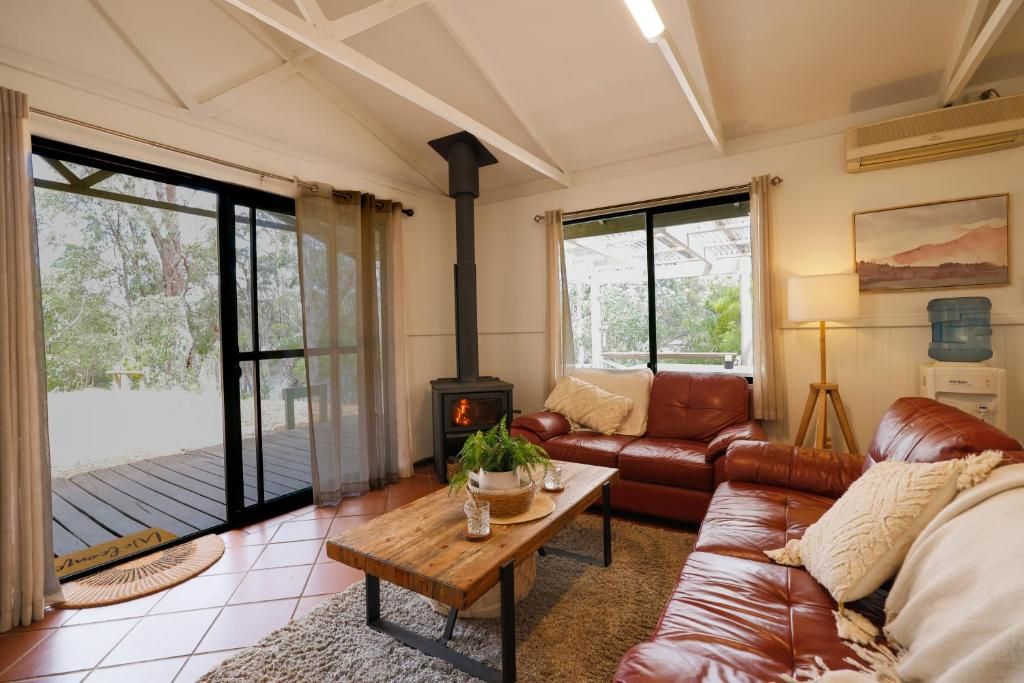 Una sala de estar acogedora con chimenea, sofá de cuero y una mesa de centro de madera.