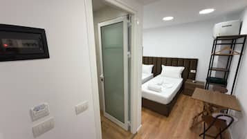Una camera d'albergo con un letto, un comodino e una sedia.