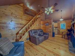 A wooden interior with a staircase, a leather sofa, and a dining area. - Cozy 1BR Loft Cabin w/hot tub, fire pit | Sleeps 4 (Sautee Nacoochee)