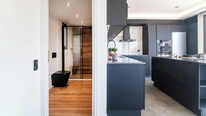 Eine moderne Küche mit einer zentralen Kochinsel, einem Einbauofen und einem großen Fenster.