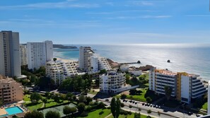 A coastal residential area with modern buildings, a beach, and a clear sky. - Apartment 'Vista Bonita' with Sea View, Wi-Fi and Air Conditioning (Portimão)