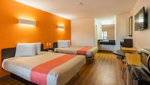 A hotel room with two beds, a small kitchenette, and a dining area. - Cozy 2 Queen Beds | Non-Smoking (Savannah GA)
