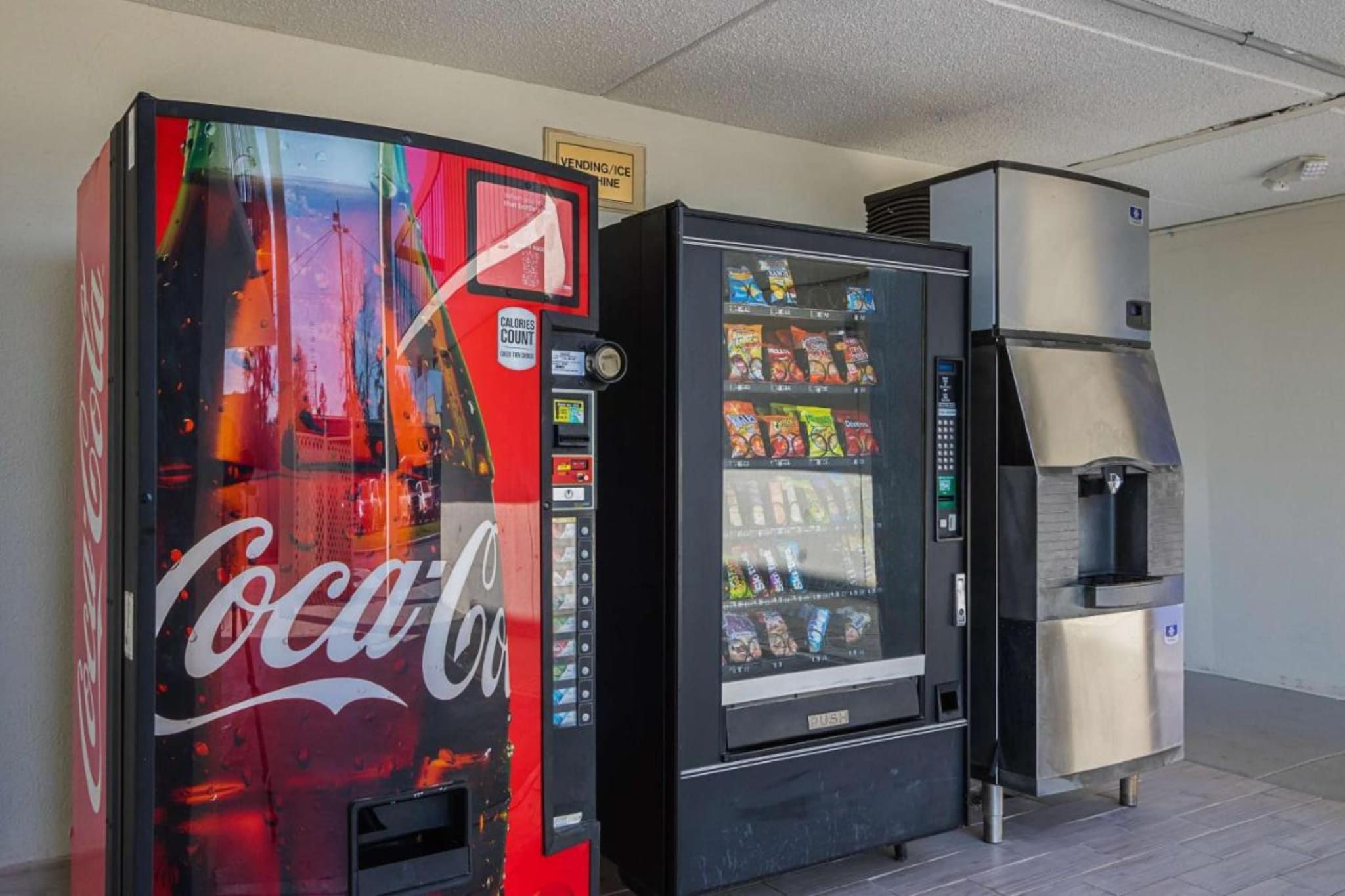 Máquina expendedora con el logotipo de Coca-Cola, máquina expendedora de snacks y dispensador de agua.