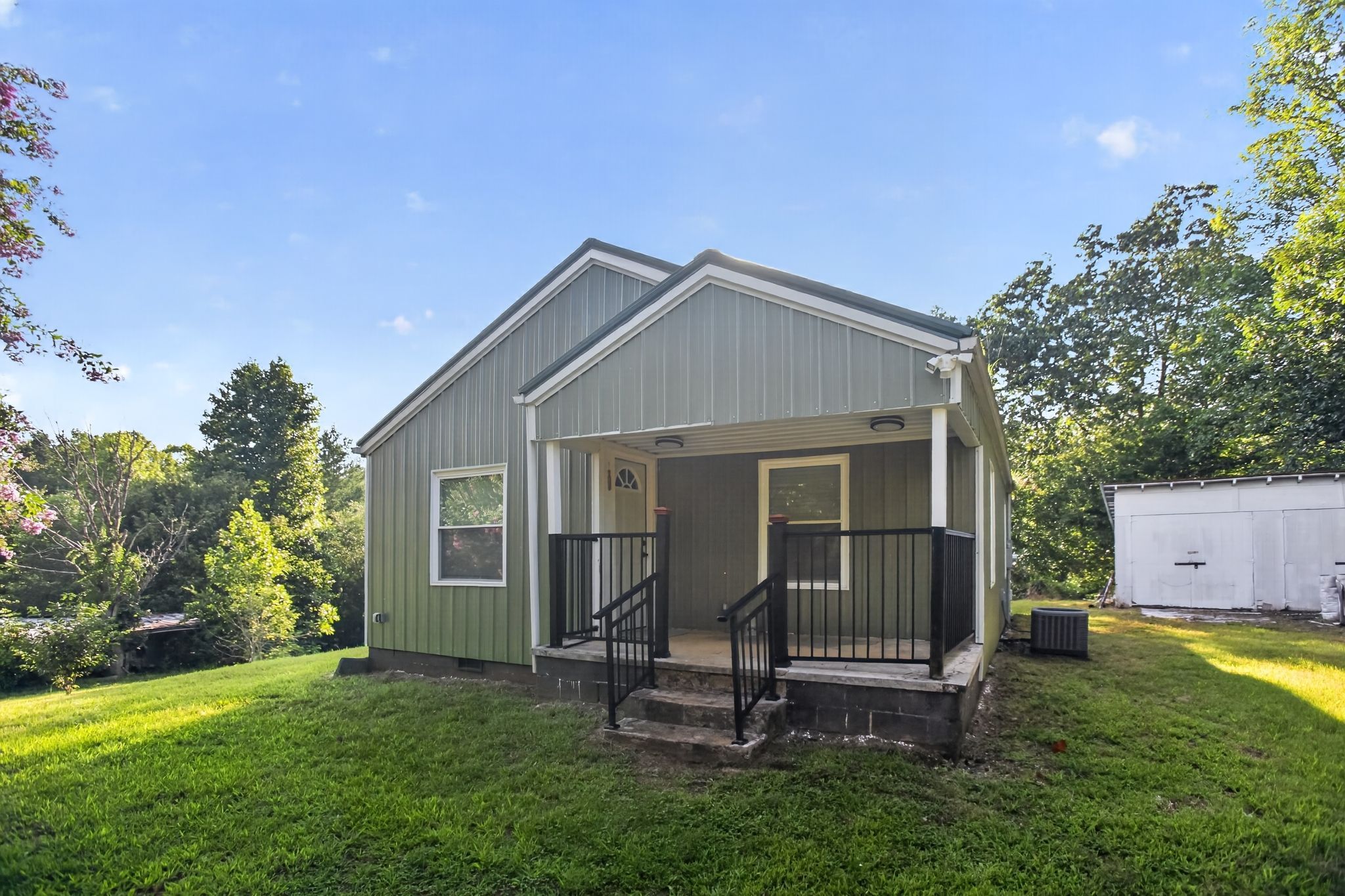 A single-story house with a front porch, a small attached garage, and a well-maintained lawn.