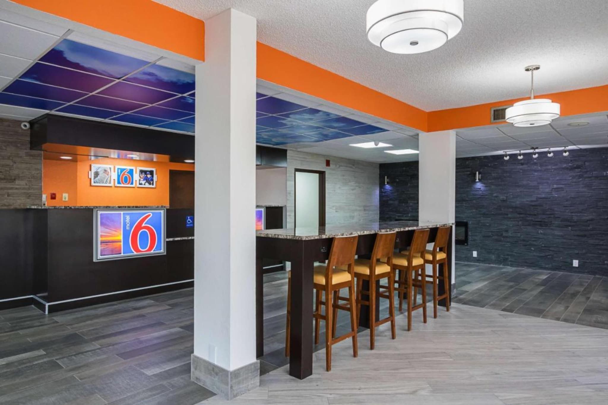 A modern interior with a reception desk, bar area, and seating.