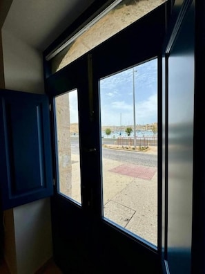 A view through a window with a clear sky and a paved area outside.