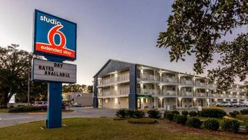 A multi-story hotel with a sign indicating Studio 6 Extended Stay rates available.