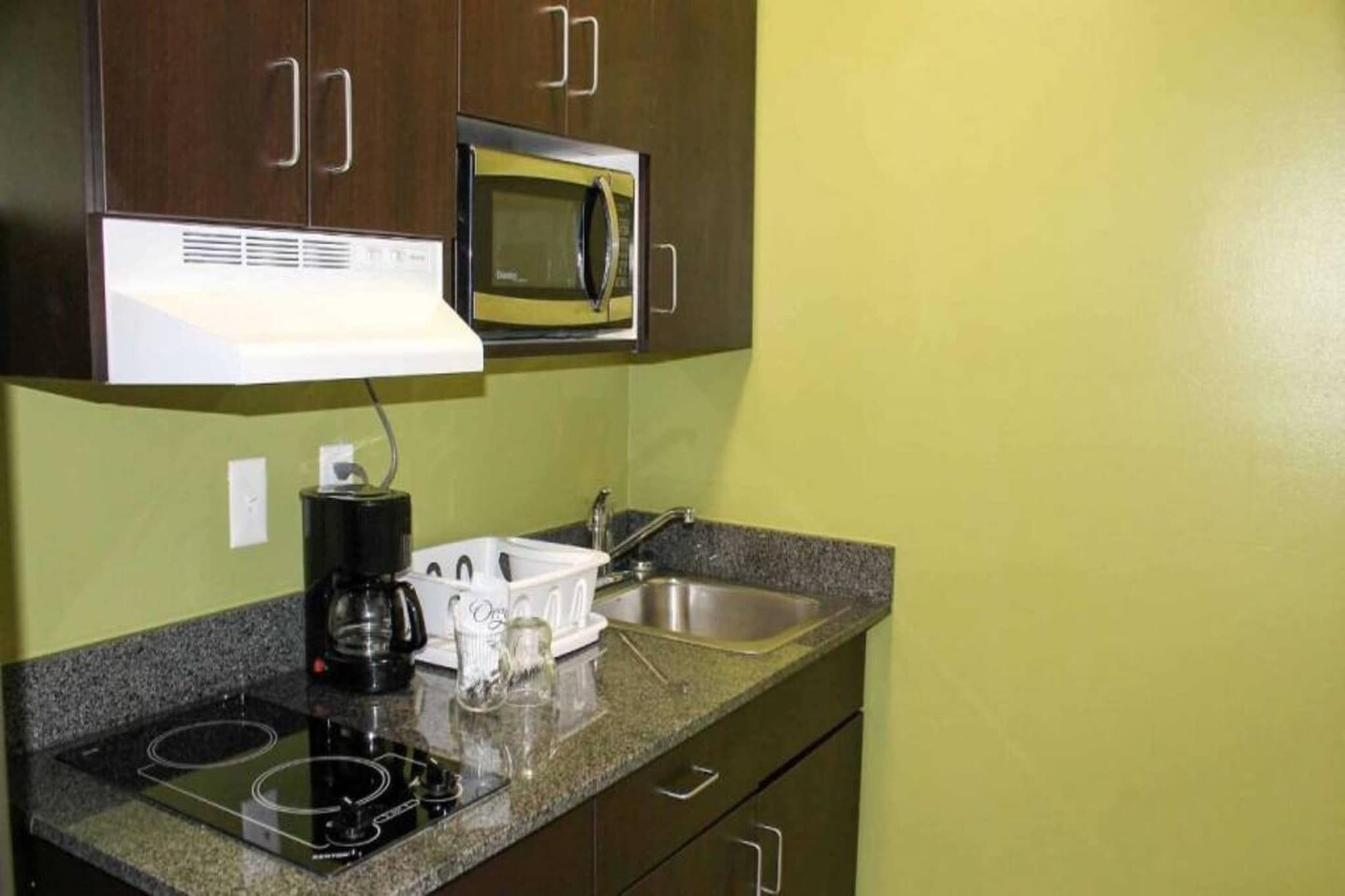 A kitchenette with a microwave, a coffee maker, and a sink.