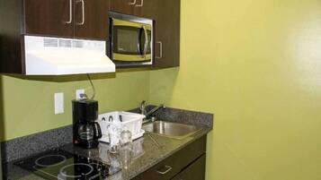 A kitchenette with a microwave, a coffee maker, and a sink.