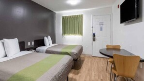 A hotel room with two beds, a desk, a chair, a television, and a window with curtains. - 2 full beds|kitchen|Non-smoking (Savannah GA)