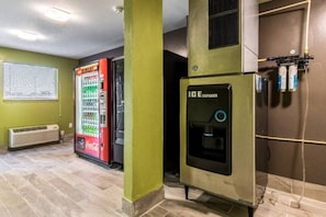 A room with a vending machine, a water dispenser, and a wall-mounted air conditioning unit. - 1 queen bed|mobili access|kitchen|Nsmk (Savannah GA)