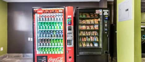 Máquina expendedora con el logotipo de Coca-Cola y un distribuidor de aperitivos.
