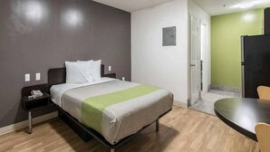A hotel room with a bed, bedside table, and a small table with chairs. - 1 king bed|kitchen|Non-smoking (Savannah GA)