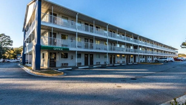 A multi-story motel with a green 'OFFICE' sign, multiple balconies, and a parking lot. - 2 full beds|Mobility access|tub|kitchen (Savannah GA)