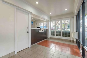 A reception area with a counter, a door, and large windows. - 1 King Bed | Smoking, Micfridge (San Jose CA)