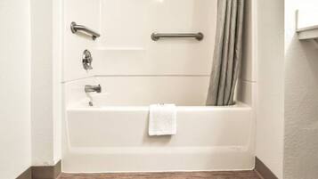 A standard hotel bathroom with a bathtub, a shower curtain, and a towel rack.