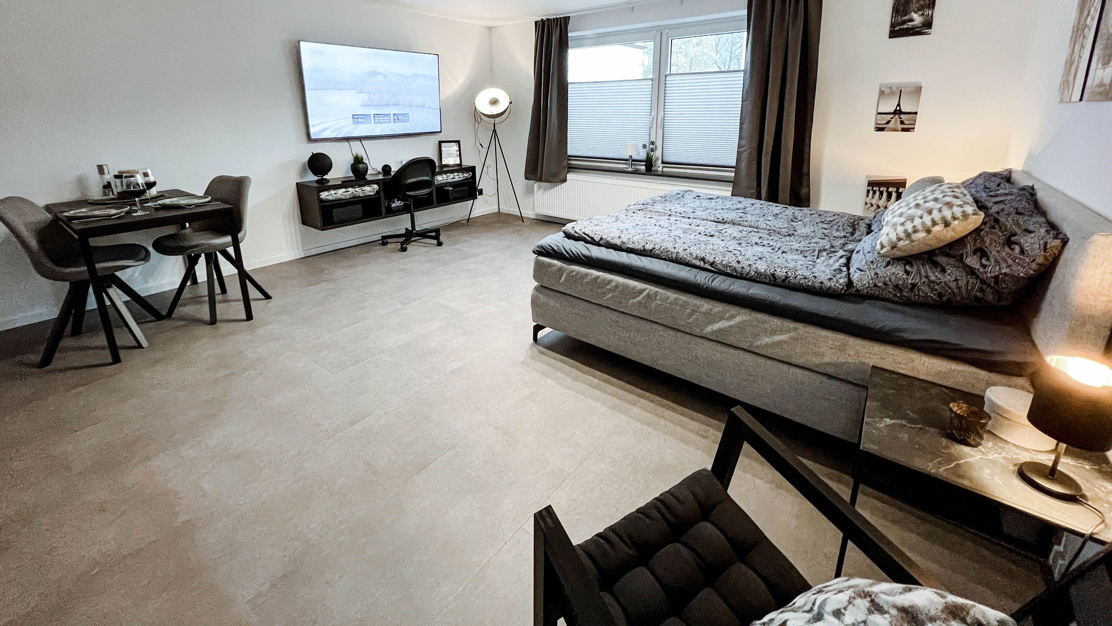 A modern bedroom with a bed, a desk, and a chair.