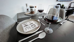 A dining table set with plates, cutlery, glasses, and a bottle, indicating a meal setting. - Apartment 'Lilia' with Shared Terrace and Wi-Fi (Dielmissen)