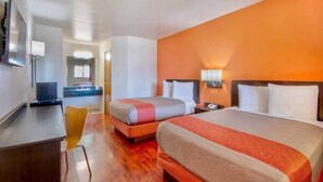 A hotel room with a bed, bedside table, and a desk with a chair. - 2 Queen Beds | Non-Smoking (Santa Nella)