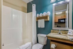 Ein Badezimmer mit Dusche, Toilette, Waschbecken und Spiegel.