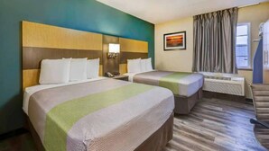 A hotel room with two beds, a nightstand with a lamp, a window with curtains, and a painting on the wall. - 2 Queen Beds|Mobil Access|Kitchen (Lenexa)
