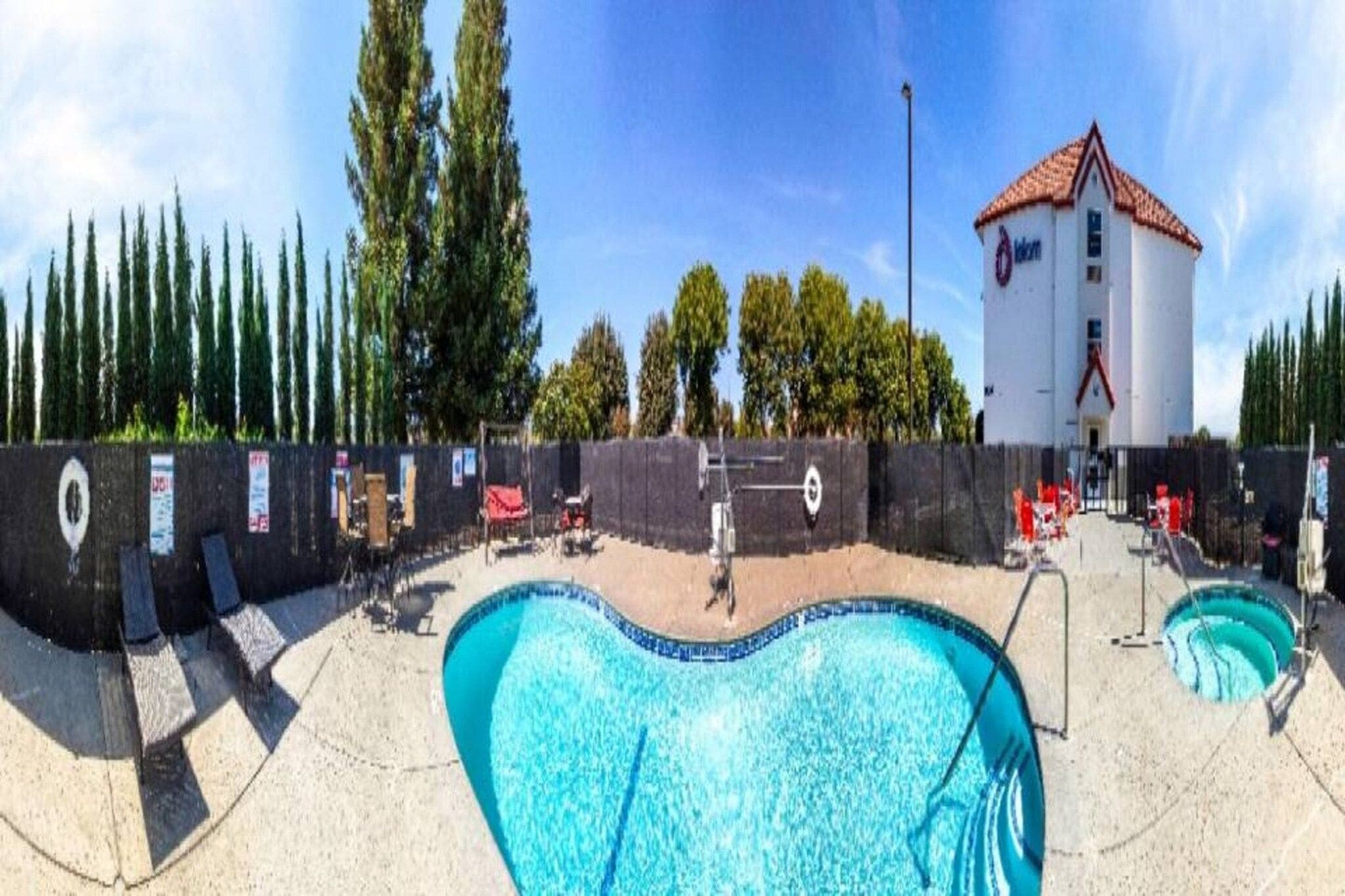 Área de piscina com um edifício ao fundo.