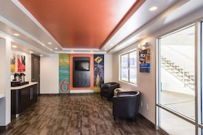 A hotel lobby with a reception desk, a seating area, a staircase, and a large window. - 2 Full Beds | Non-smoking (Oroville)