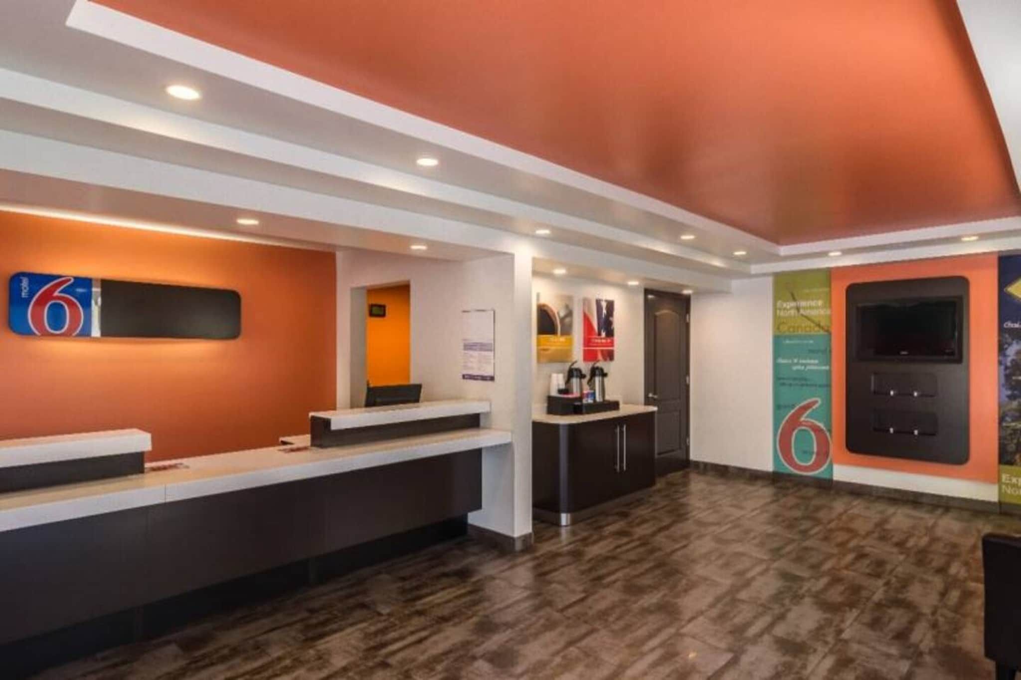 A reception area with a counter, a coffee machine, and a wall-mounted TV.