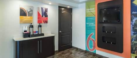 Zona de recepción con mostrador, una puerta y una pared con un gran cartel con el número 6.