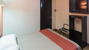 Habitación de hotel con cama, televisión, escritorio y silla.