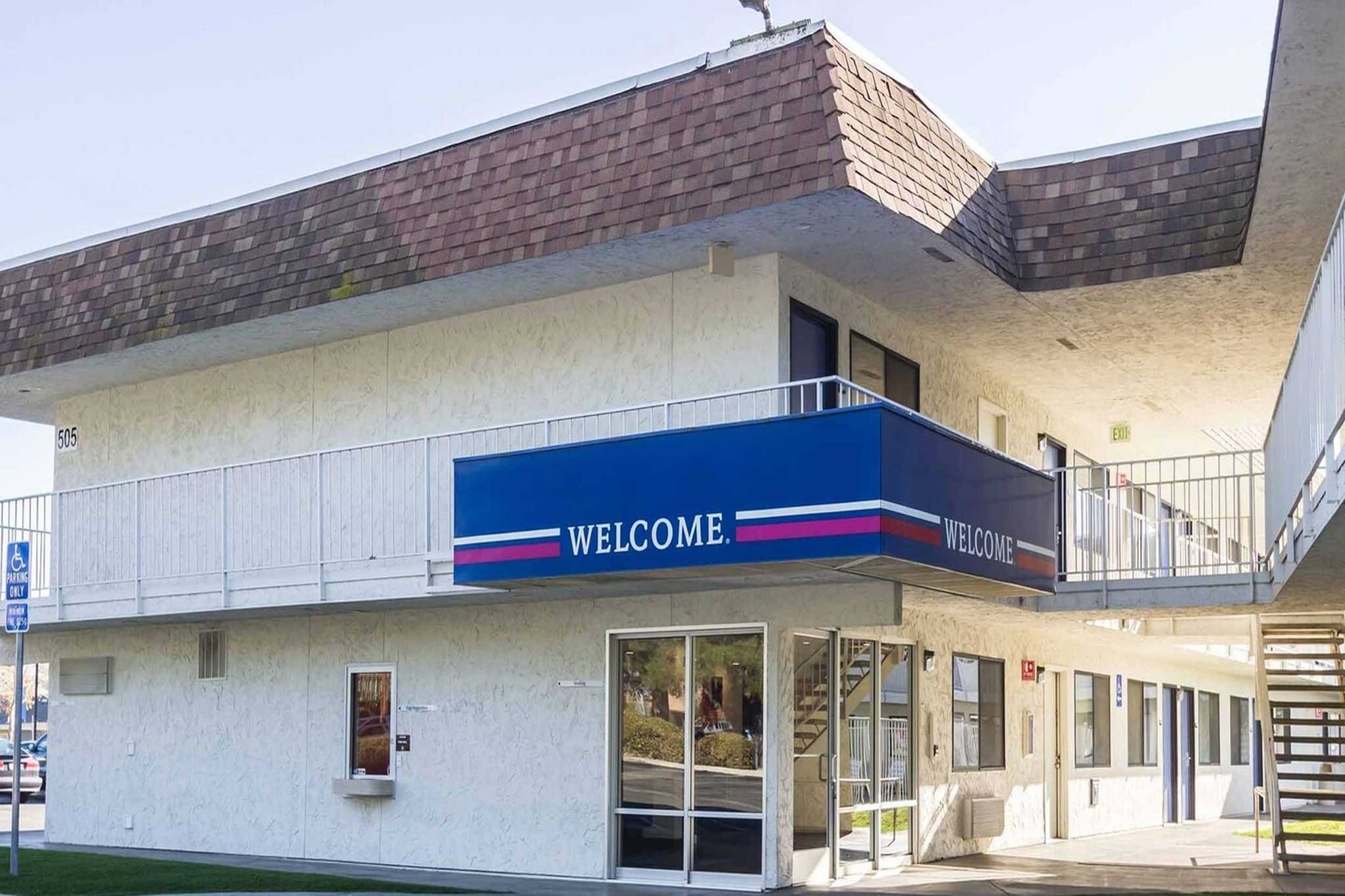 Un immeuble à plusieurs étages, avec une enseigne « BIENVENUE » au rez-de-chaussée.