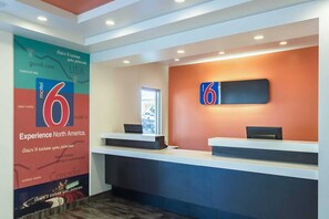 A reception area with a large '6' sign, a window, and a wall-mounted signboard.
