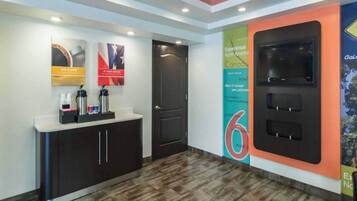 Zona de recepción con mostrador, una puerta y una pared con un gran cartel con el número 6.
