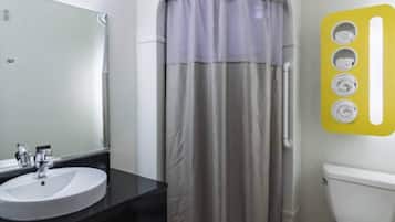 Ein Badezimmer mit Waschbecken, Spiegel, Toilette und Duschvorhang.