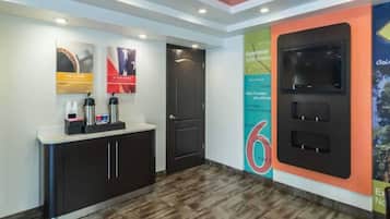 Zona de recepción con mostrador, puerta y pared con el número '6' y un cartel.