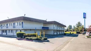 A two-story motel with a 'Welcome' sign, a parking lot, and a '6' sign indicating the motel's number. - 2 Full Beds | Smoking (Oroville)