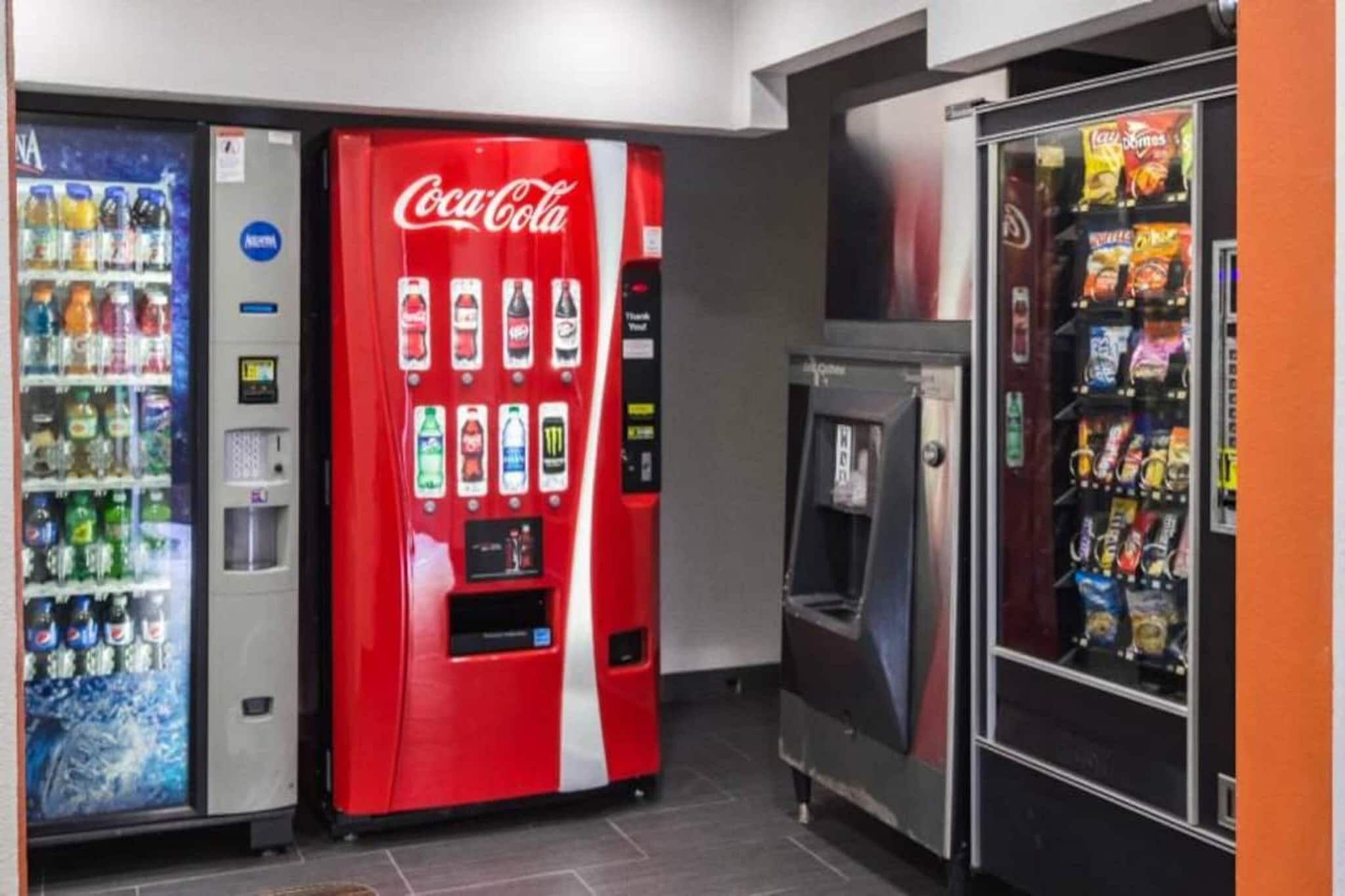 Alue, jossa on myyntiautomaatteja: Coca-Cola-automaatti, juomavesiautomaatti ja välipaloautomaatti.