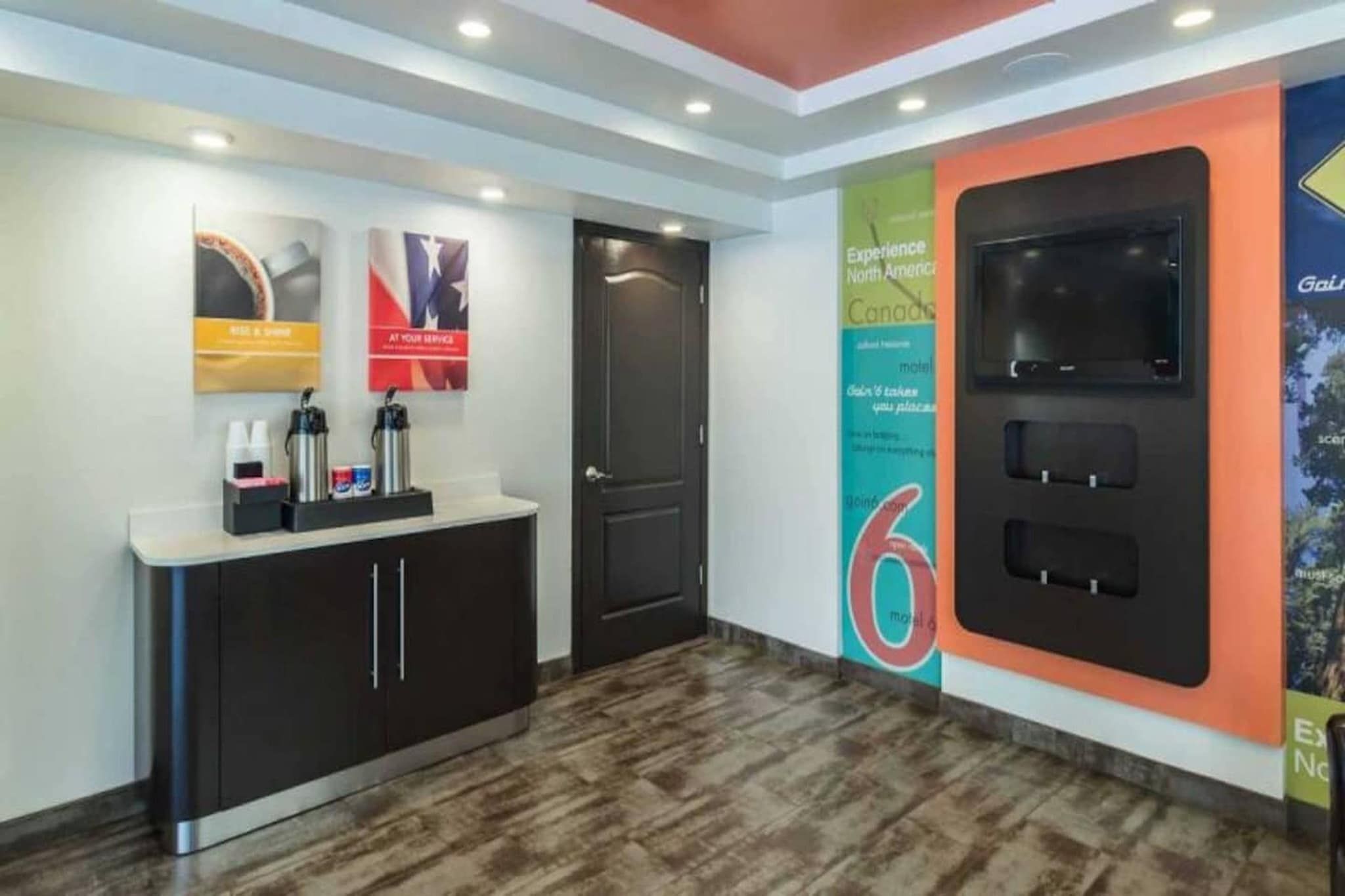 A reception area with a counter, a door, and a wall with a large number '6' and a poster.