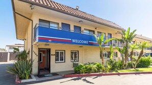 A building with a 'WELCOME' sign, a balcony, and a number '1260' on the facade. - 1 QUEEN BED | Nsmk, MINI FRIDGE (Riverside)