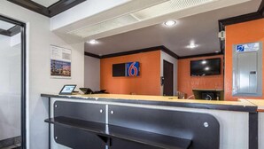 A hotel reception area with a counter, a digital display, and a sign indicating room number 6. - Sunny 2-Bed Full Beds|Mini Fridge (Riverside)