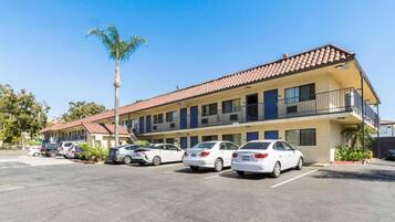 A multi-story motel with a parking lot.