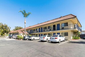 Un motel de varios pisos con estacionamiento.