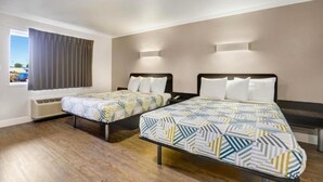 Habitación de hotel con dos camas, una ventana con cortinas, un calefactor y vista al exterior.
