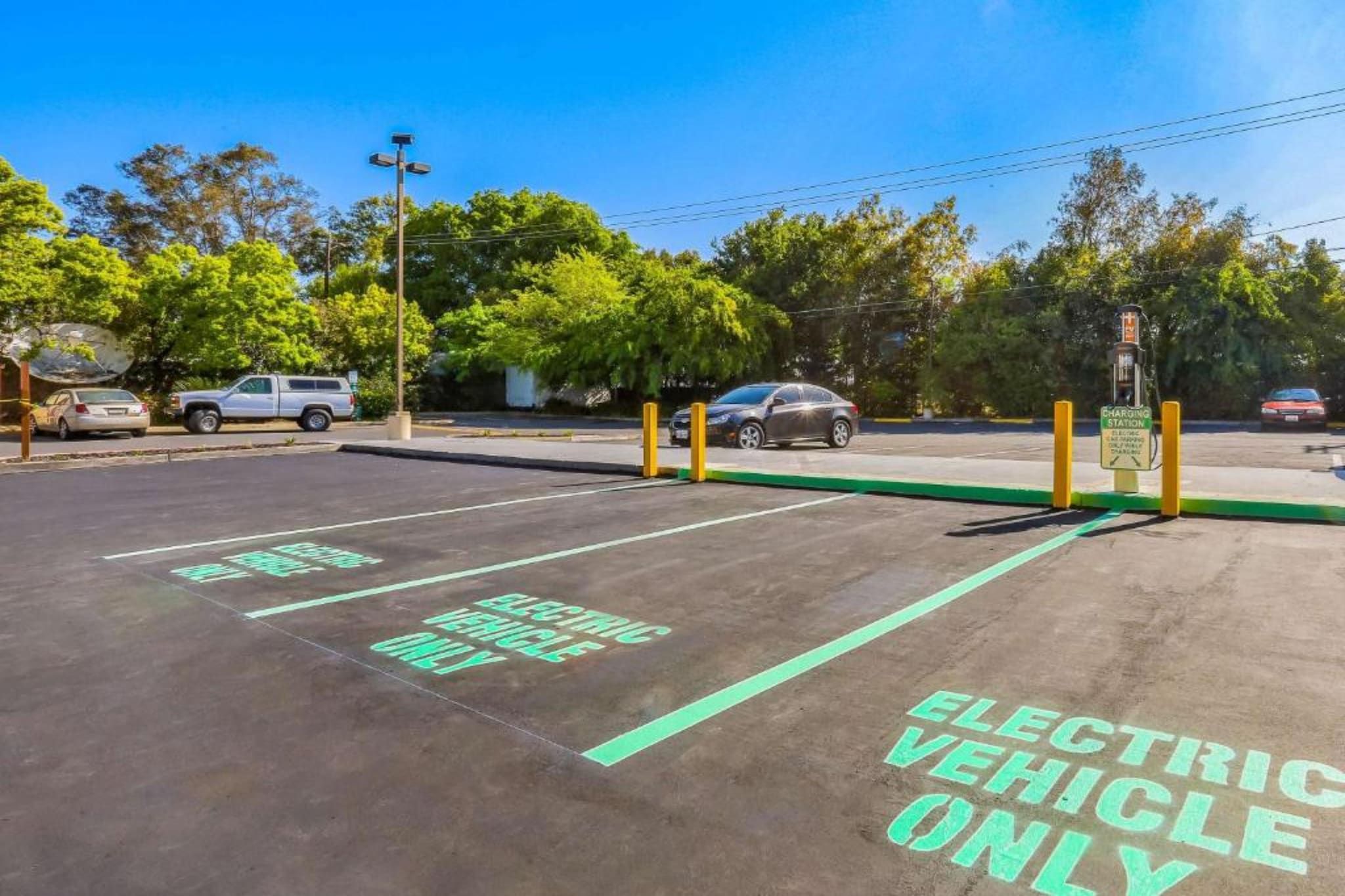 Un área de estacionamiento con estaciones de carga para vehículos eléctricos y espacios designados.