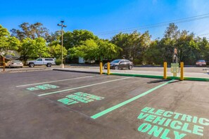 Un espace de stationnement équipé de bornes de recharge pour véhicules électriques et comprenant des places de stationnement réservées.